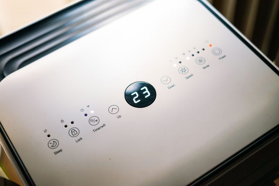 Ar condicionado portátil junto a uma janela numa sala